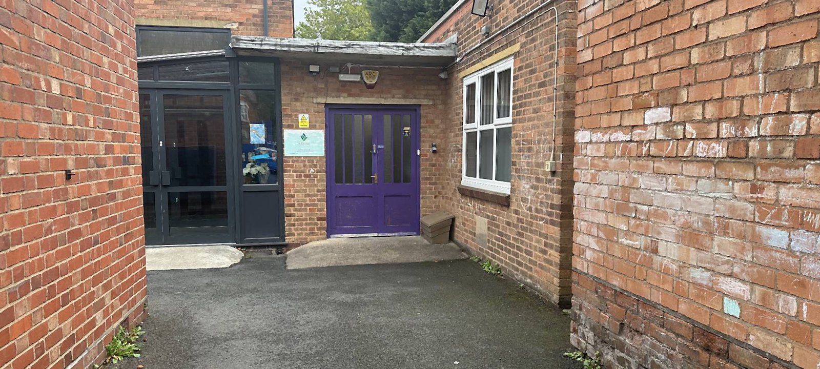 The entrance to Aspire Hall Green: a purple door set in red brick, with a glazed porch beside it